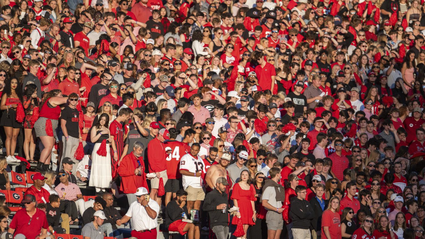 A crowd of University of Georgia fans wearing red at a football game.