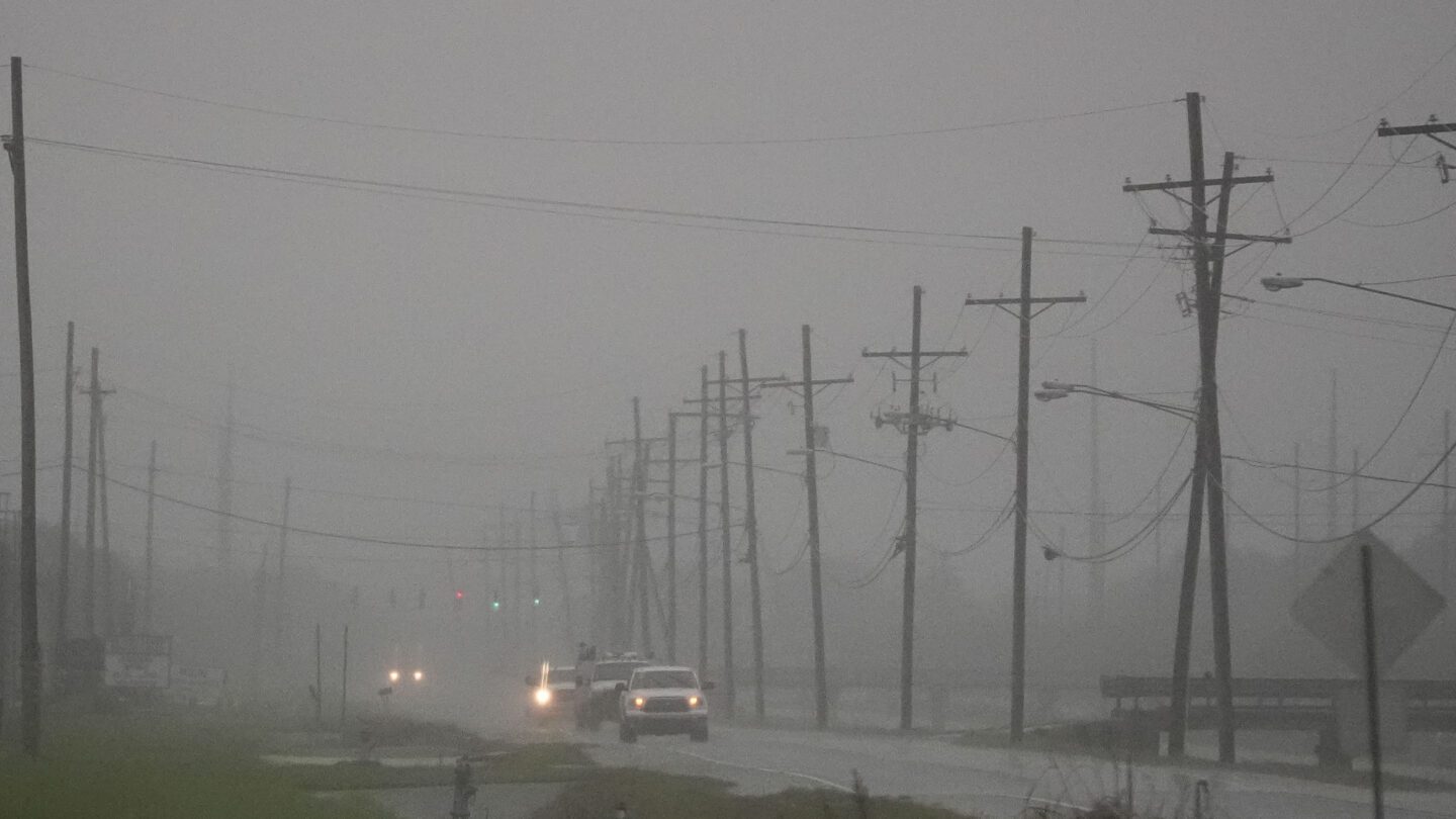 Cars drive through a thick fog outside of New Orleans ahead of Hurricane Francine