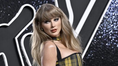 Taylor Swift poses for photos at the MTV Video Music Awards against a black and white backdrop.