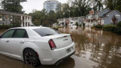 A car is partially submerged in water in a neighborhood in Atlanta.