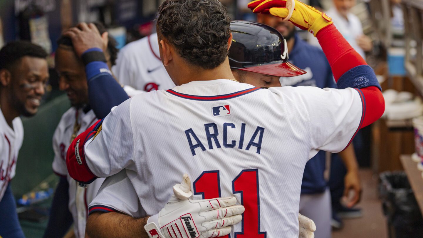 Atlanta Braves' Ramon Laureano, behind, hugs Atlanta Braves Orlando Arcia, front, in the dugout after hitting a solo home run to centerfield in the sixth inning of a baseball game against the New York Mets, Monday, Sept. 30, 2024, in Atlanta.