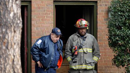 Fire officials standing outside of a building