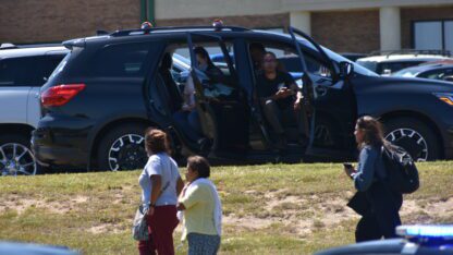 Parents sit in a car parked near the Apalachee High School after a fatal shooting on Sept. 4, 2024.