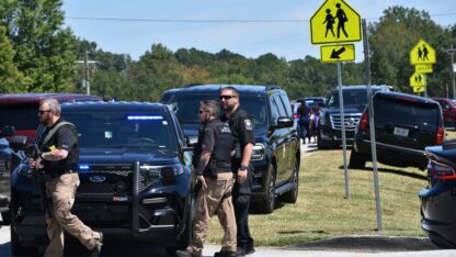 Police officers gather near Apalachee High School after a fatal shooting at the school.