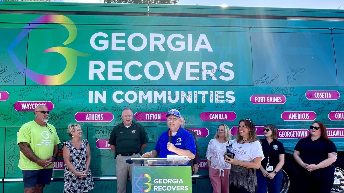 Jeff Breedlove speaks on the Georgia Recovers bus tour in front of a Georgia Recovers bus.