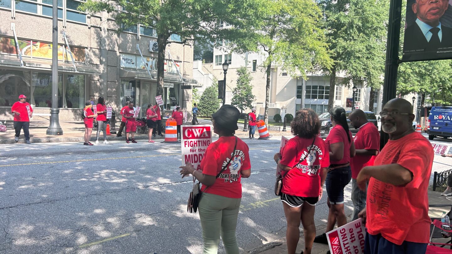 Striking workers gather on both sides of a street.