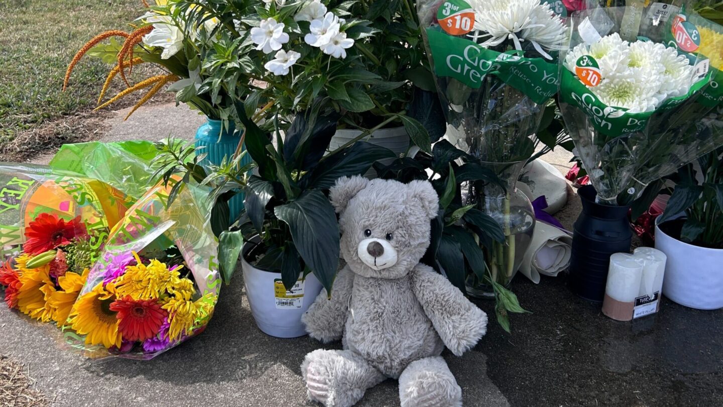 Bouquets of flowers and a teddy bear are among the items left at a flag pole near the Apalachee High School by mourners following a deadly shooting at the school on Sept. 4, 2024.