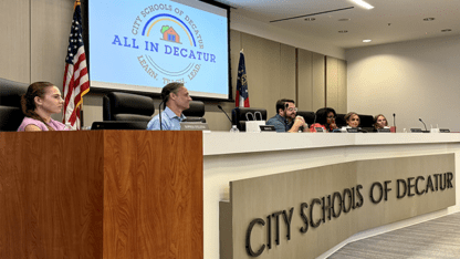 The City Schools of Decatur board sits at a long table during its meeting.