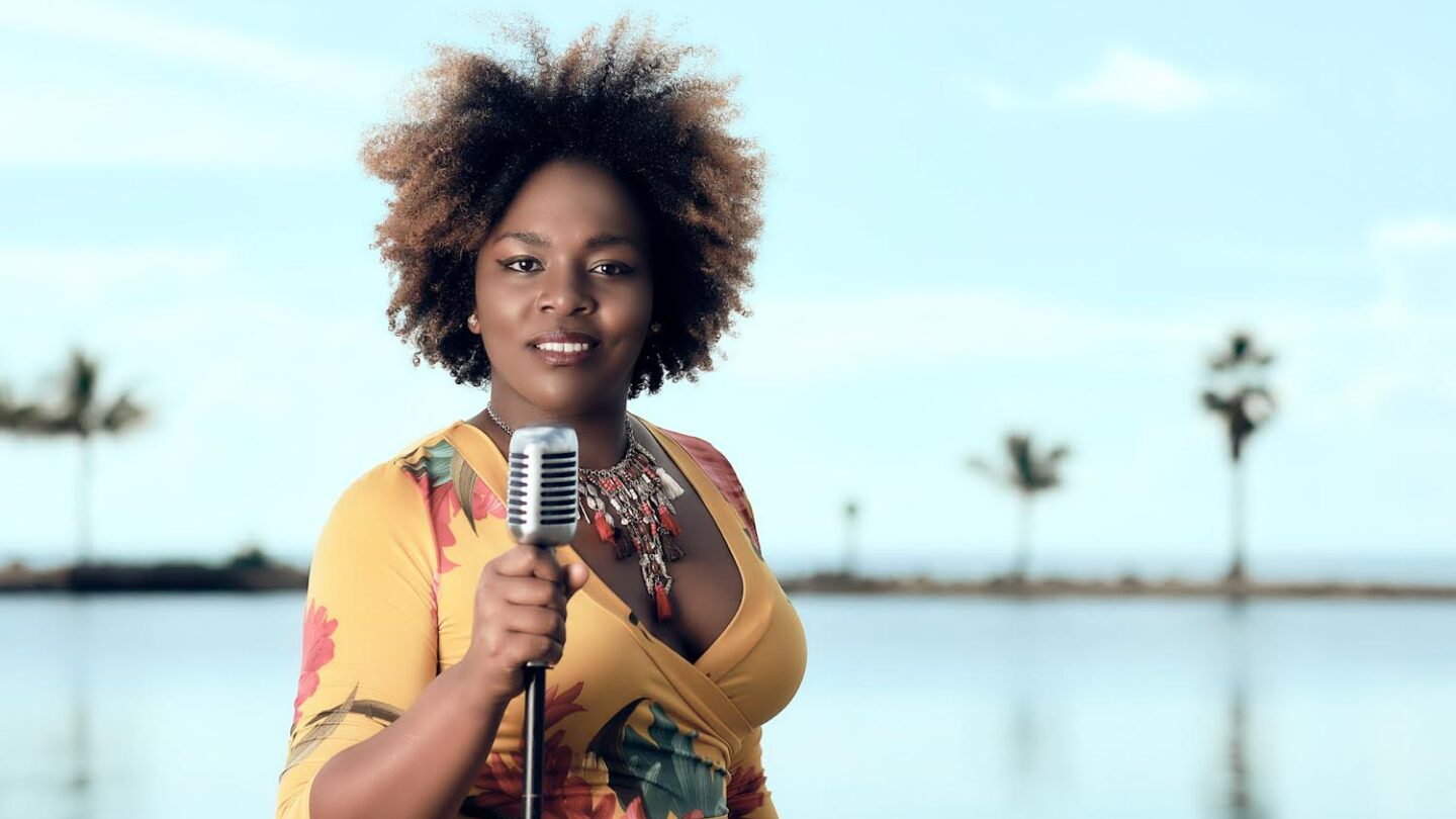 Jessy Diaz holds a microphone in front of a body of water.