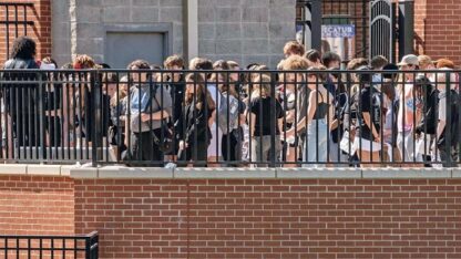 A group of students are standing at the Decatur High School stadium.