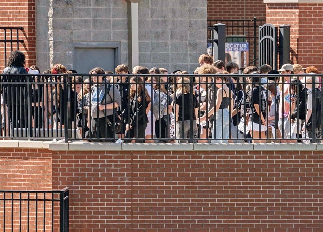 A group of students are standing at the Decatur High School stadium.