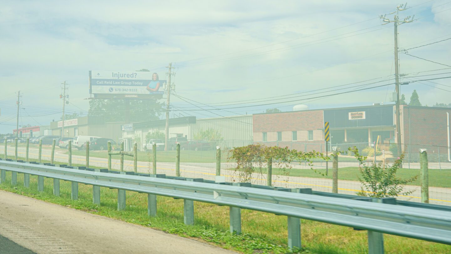 Smoke hangs over a roadside.