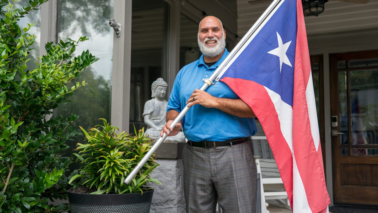 Louis Negron, an Afro Latino, with a Puerto Rican flag at his home