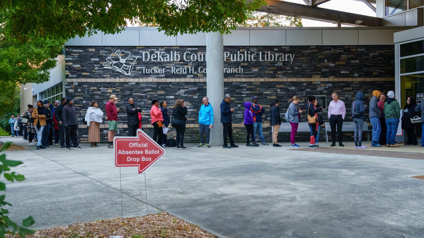 People line up around the building at the Tucker-Reid H. Cofer branch of the Dekalb County Public Library on the first day of early voting.