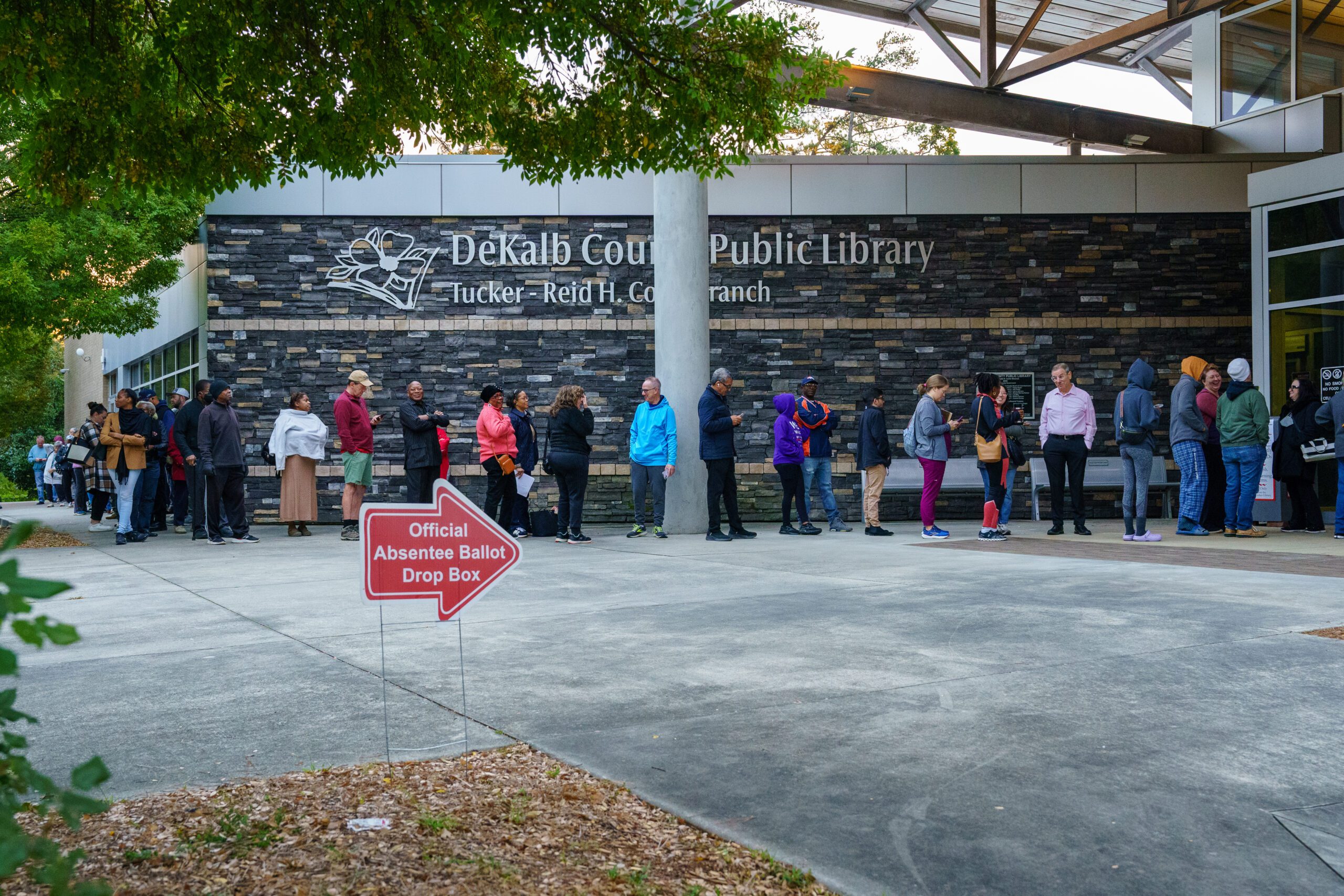 People line up around the building at the Tucker-Reid H. Cofer branch of the Dekalb County Public Library on the first day of early voting.