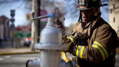 A firefighter is opening a fire hydrant.