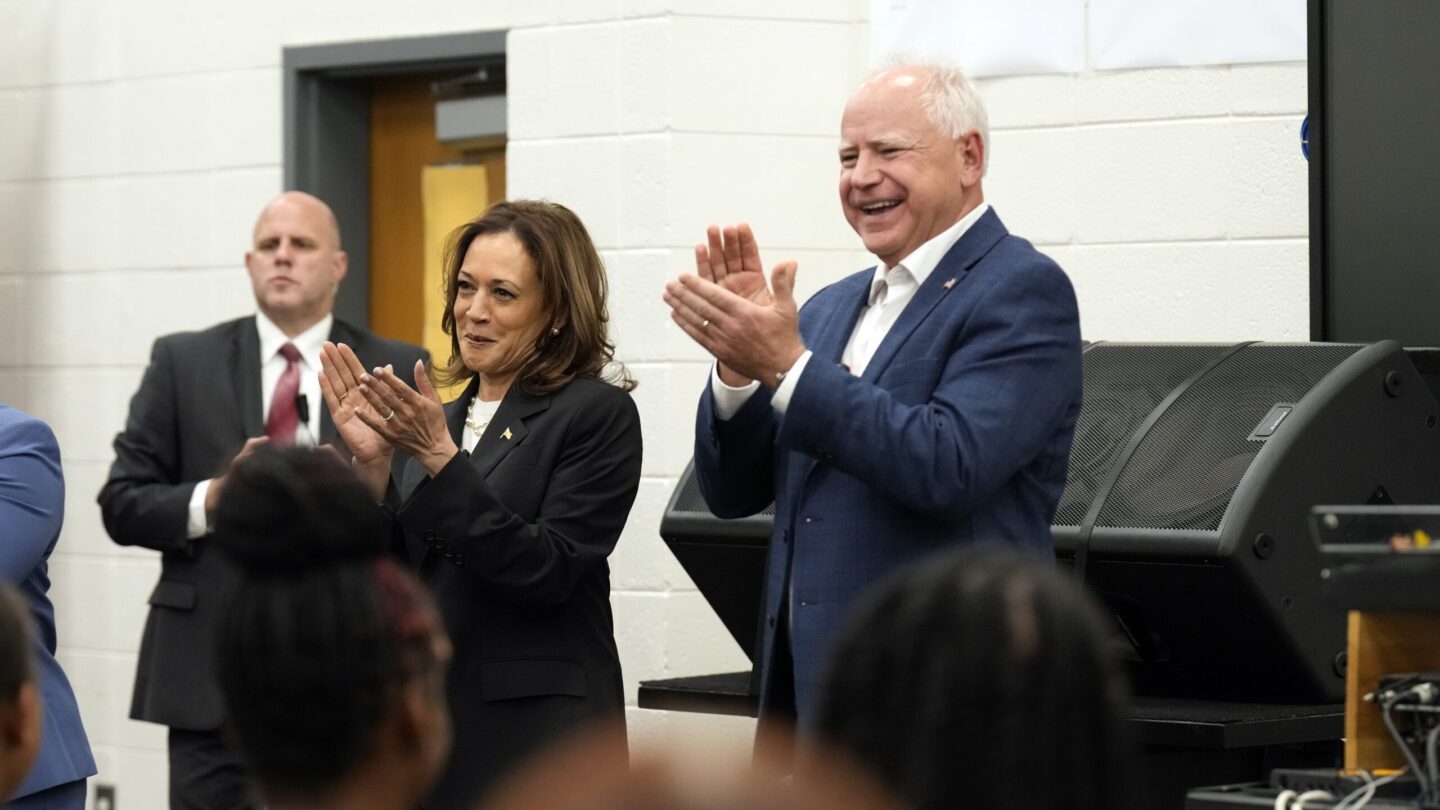 Kamala Harris, left, and Tim Walz, right clap during a band rehearsal.