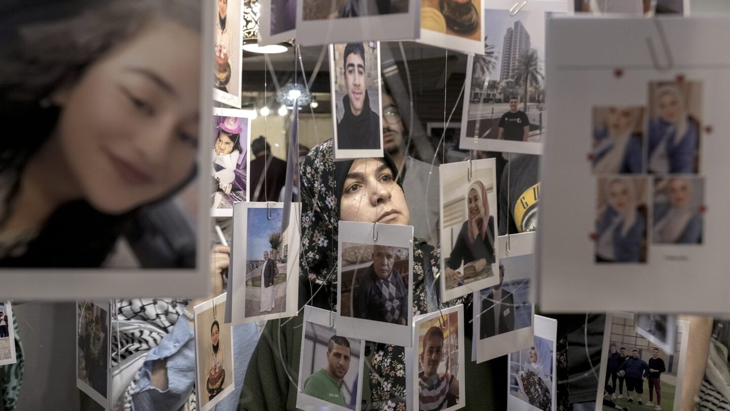 A woman looks at photos hanging from the ceiling of Palestinians who died in the Israel-Hamas war.