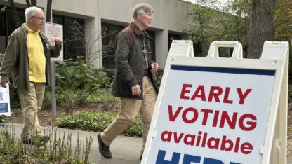 People leave after voting in the Atlanta suburb of Sandy Springs. A sign saying Early Voting available Here stands in the foreground.