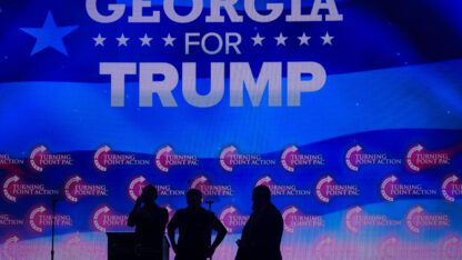 Georgia for Trump is projected in the background of a Gas South Arena rally for Trump.