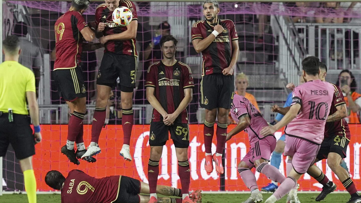 Several Atlanta United players jump in the air next to the goal.