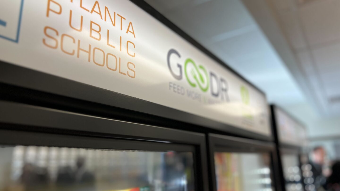 The logos of the Atlanta Public Schools and Goodr on top of a freezer.