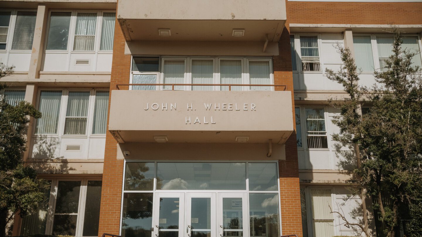 An orange brick building with the words John H. Wheeler on it.