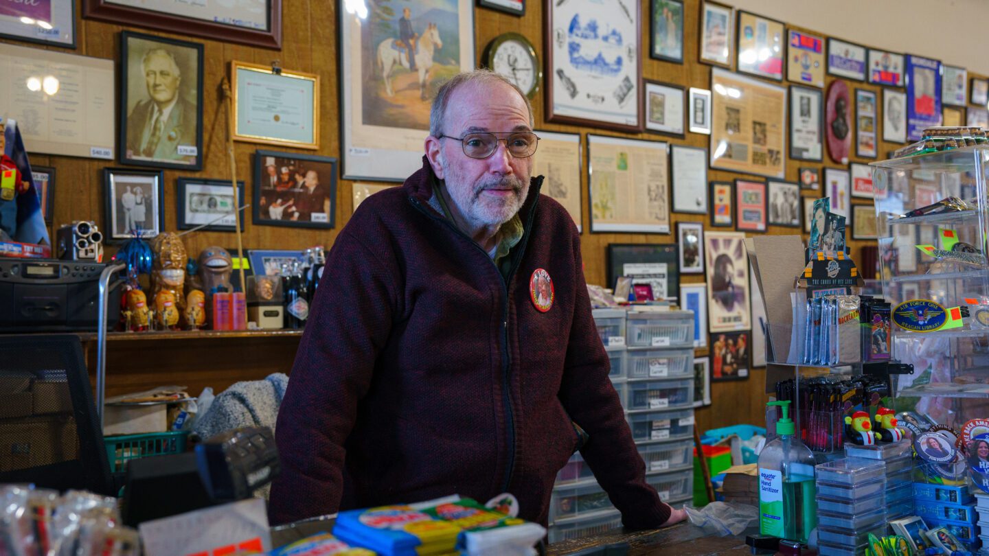 Philip Kurland, the longtime owner of the Plains Trading Post on Main Street, stands amid a sea of pins and memorabilia from past campaigns.